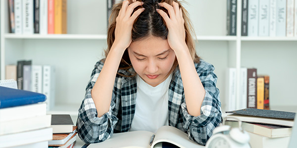 jovem com a mão na cabeça estressada 